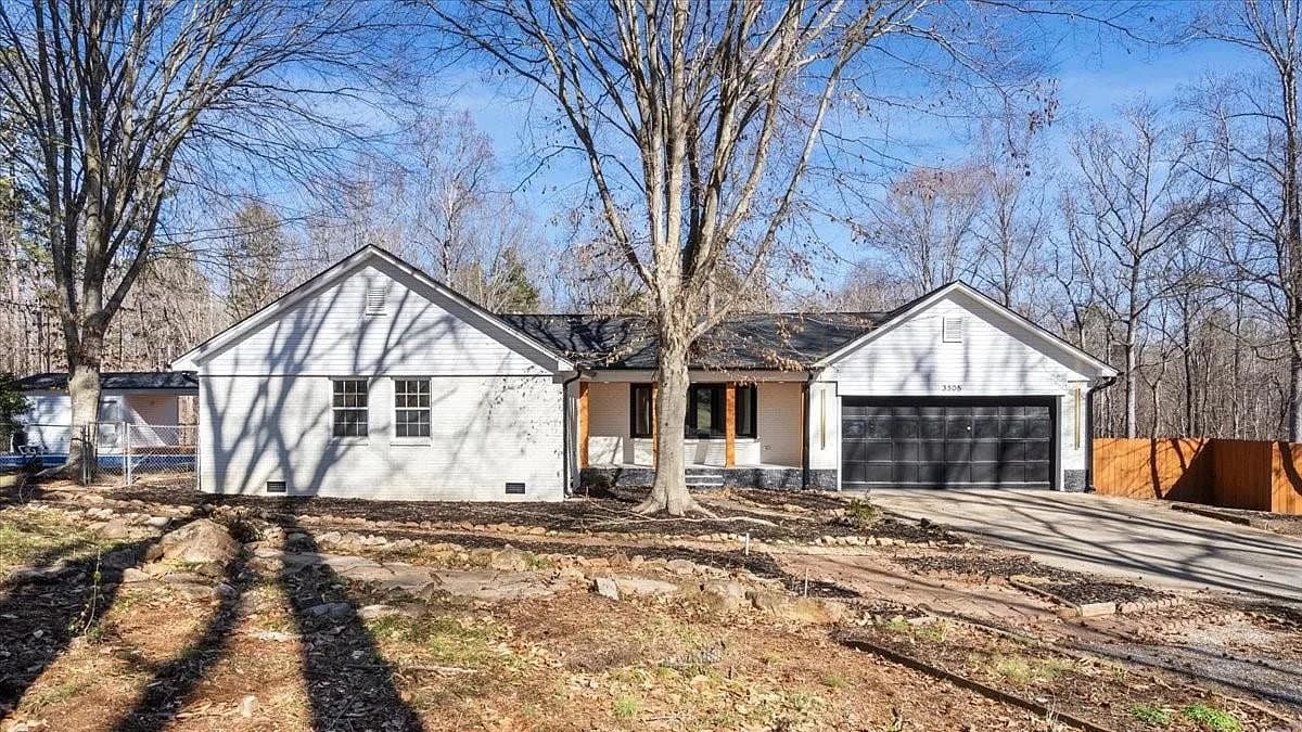 Front elevation of the ranch home, with charcoal shingles across the main roof, the porch, and the attached two-car garage.